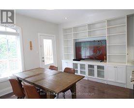 A dining room with a wooden table and chairs.