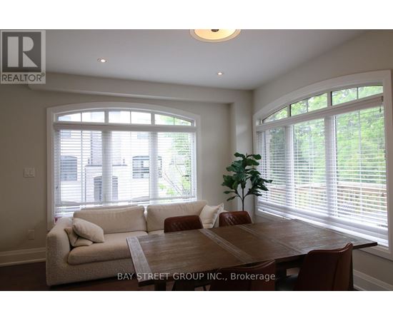 A well-lit dining room with a wooden table and chairs.