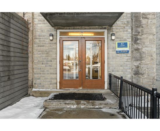 The entrance to a building with a brown door and a sign above it.