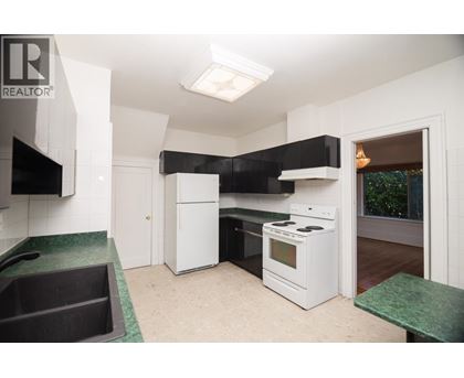 A kitchen with white appliances and a green counter.