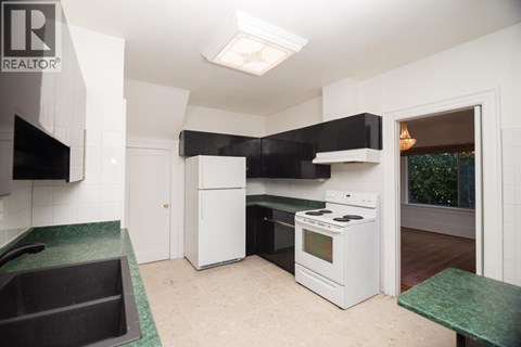 A kitchen with white appliances and a green counter.
