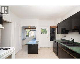 A kitchen with a black counter top and a white stove top.