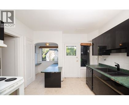 A kitchen with a black counter top and a white stove top.