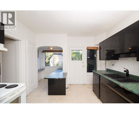 A kitchen with a black counter top and a white stove top.