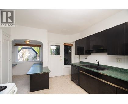 A kitchen with black cabinets and a green countertop.