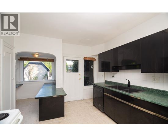 A kitchen with black cabinets and a green countertop.
