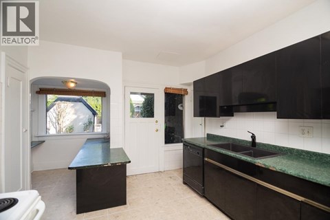 A kitchen with black cabinets and a green countertop.