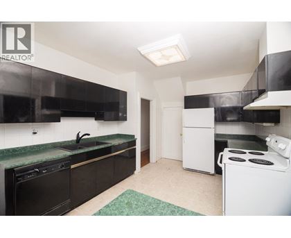 A kitchen with black cabinets and a green countertop.