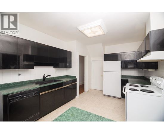 A kitchen with black cabinets and a green countertop.
