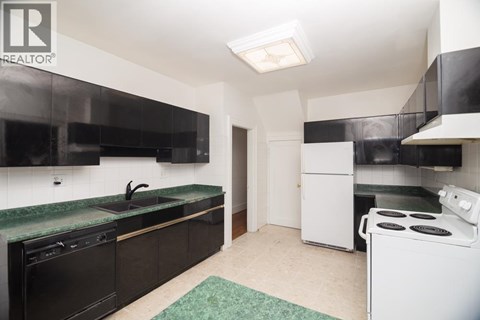 A kitchen with black cabinets and a green countertop.