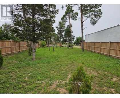 A backyard with a fence and trees.