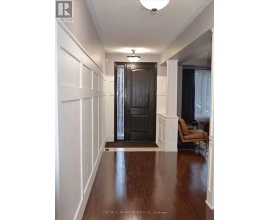 A hallway with a black door and a brown floor.