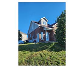 A house with a red brick exterior and white trim.