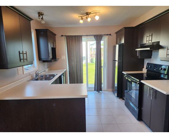 A kitchen with black cabinets and a white countertop.