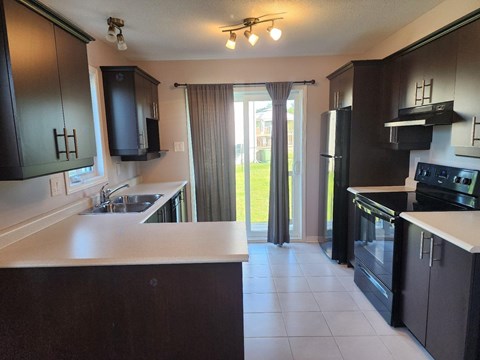 A kitchen with black cabinets and a white countertop.
