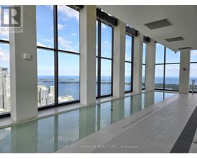 A large room with floor to ceiling windows overlooking a body of water.