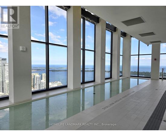 A large room with floor to ceiling windows overlooking a body of water.