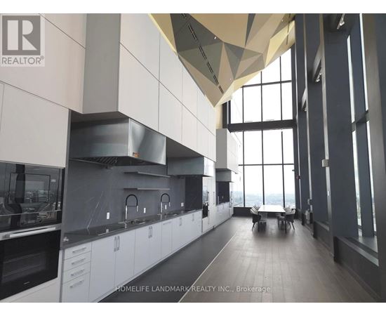 A modern kitchen with white cabinets and a large window.