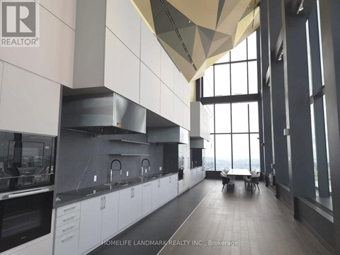 A modern kitchen with white cabinets and a large window.