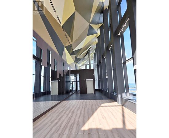 A modern interior space with wooden floors and geometric ceiling design.