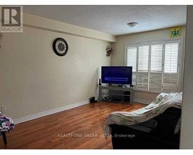 A living room with a flat screen TV and a clock on the wall.