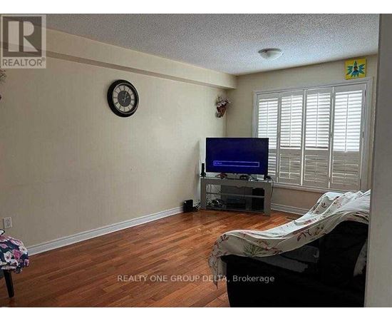 A living room with a flat screen TV and a clock on the wall.