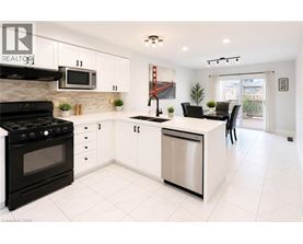 A modern kitchen with white cabinets and black appliances.