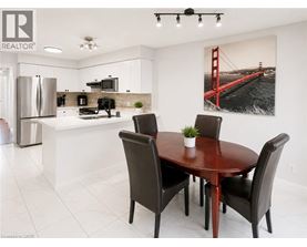 A dining room with a table and chairs and a picture of the Golden Gate Bridge on the wall.