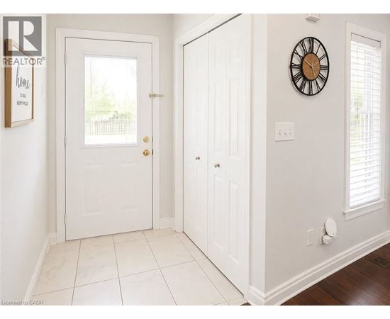 A white door with a clock on the wall.