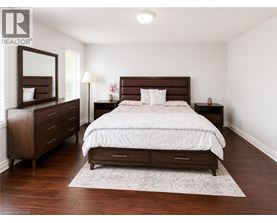 A bedroom with a large bed, a dresser, and a nightstand.