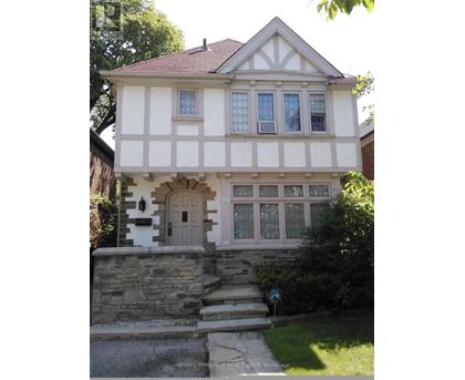 A house with a white and black facade and a brown roof.