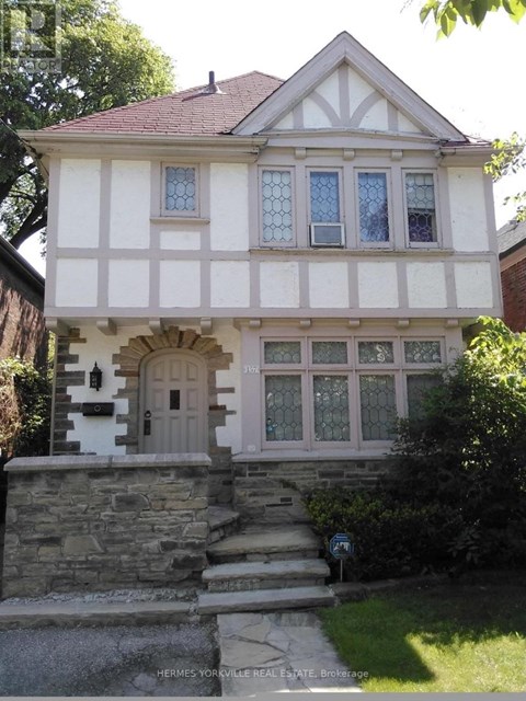 A house with a white and black facade and a brown roof.