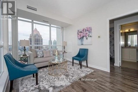 A living room with a blue chair and a sofa.