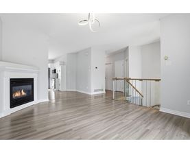 A living room with a fireplace and a staircase.