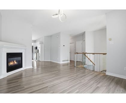 A living room with a fireplace and a staircase.