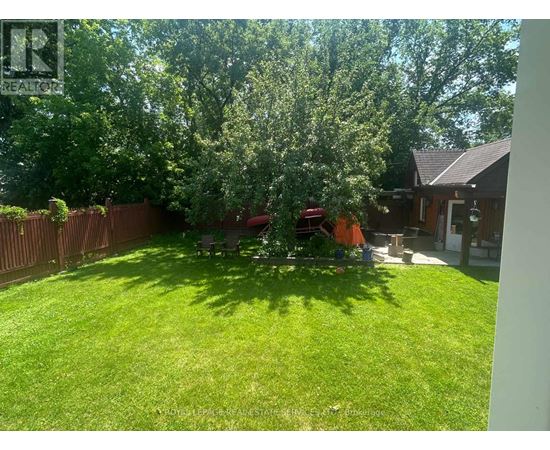 A backyard with a lawn and trees.