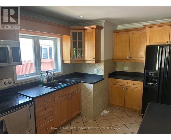 A kitchen with wooden cabinets and black countertops.