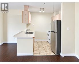 A kitchen with a white counter top and a stainless steel refrigerator.