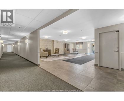 A spacious hallway with a carpeted floor and a door on the right.