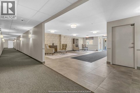 A spacious hallway with a carpeted floor and a door on the right.