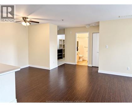 A room with a ceiling fan and wooden flooring.