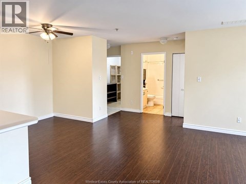 A room with a ceiling fan and wooden flooring.