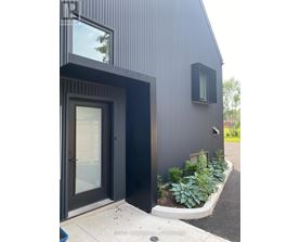 A modern house with a black exterior and a glass door.