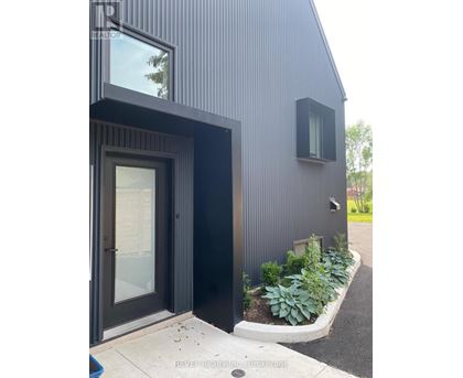 A modern house with a black exterior and a glass door.