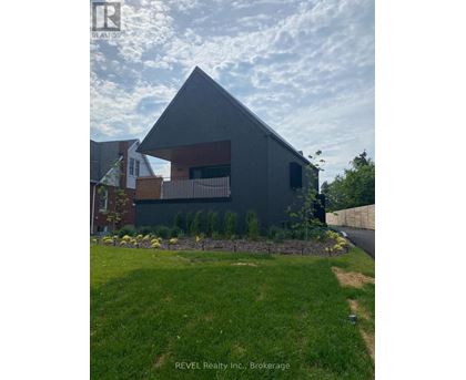 A modern house with a grey exterior and a well-maintained lawn in front.