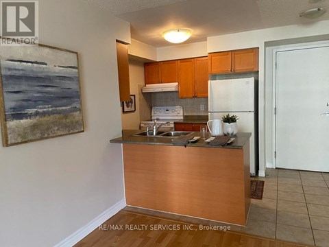 A kitchen with a wooden counter and a painting on the wall.