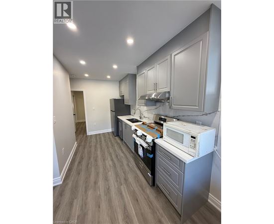 A kitchen with a white microwave oven on a counter.
