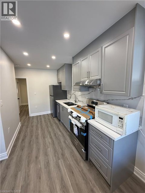 A kitchen with a white microwave oven on a counter.