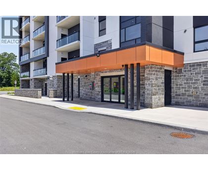 A modern building with a glass entrance and a stone wall.