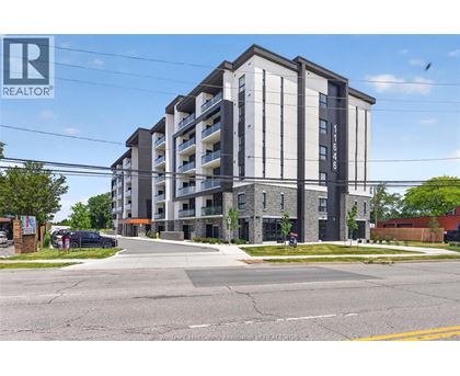 A modern apartment building with a clear blue sky in the background.